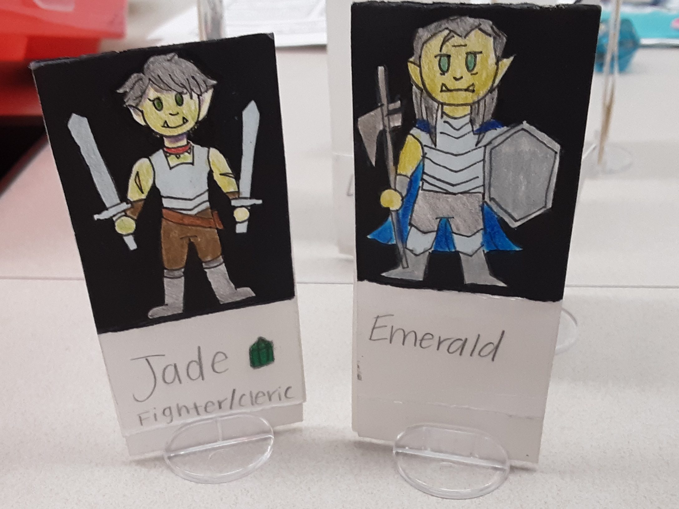 Two half-orcs wearing armor named Jade and Emerald.